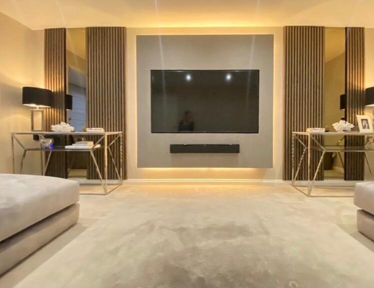 Bedroom media wall with slatted timber panels and integrated bedside lighting
