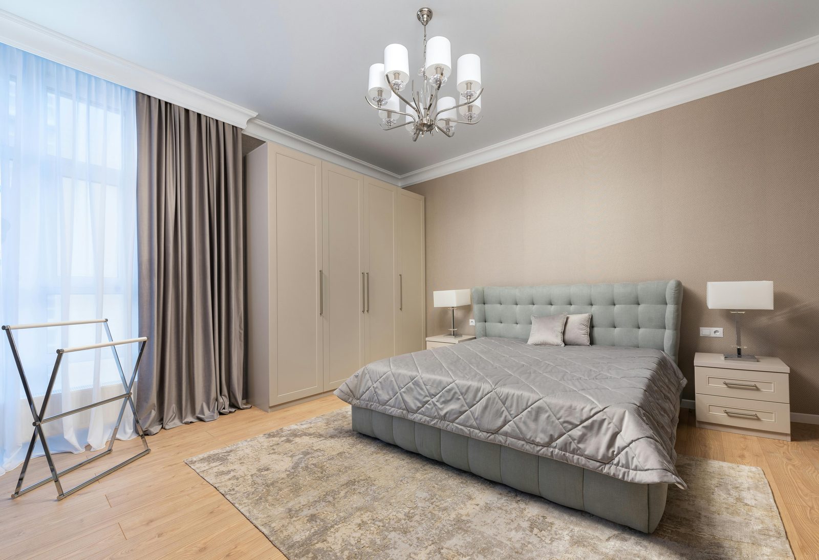 Calm neutral bedroom with full-height fitted wardrobes alongside the bed