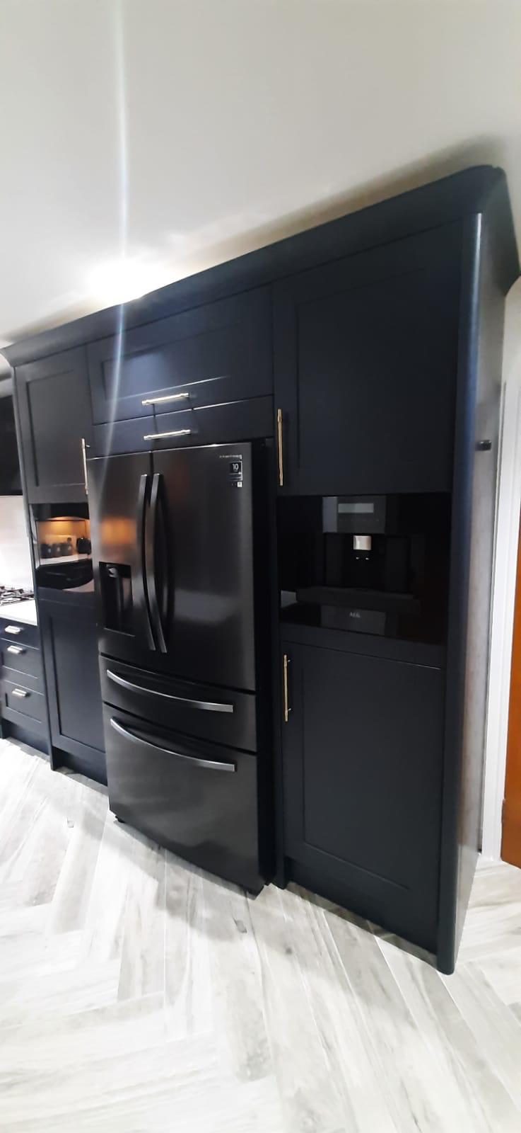 Black american fridge integrated into navy cabinetry